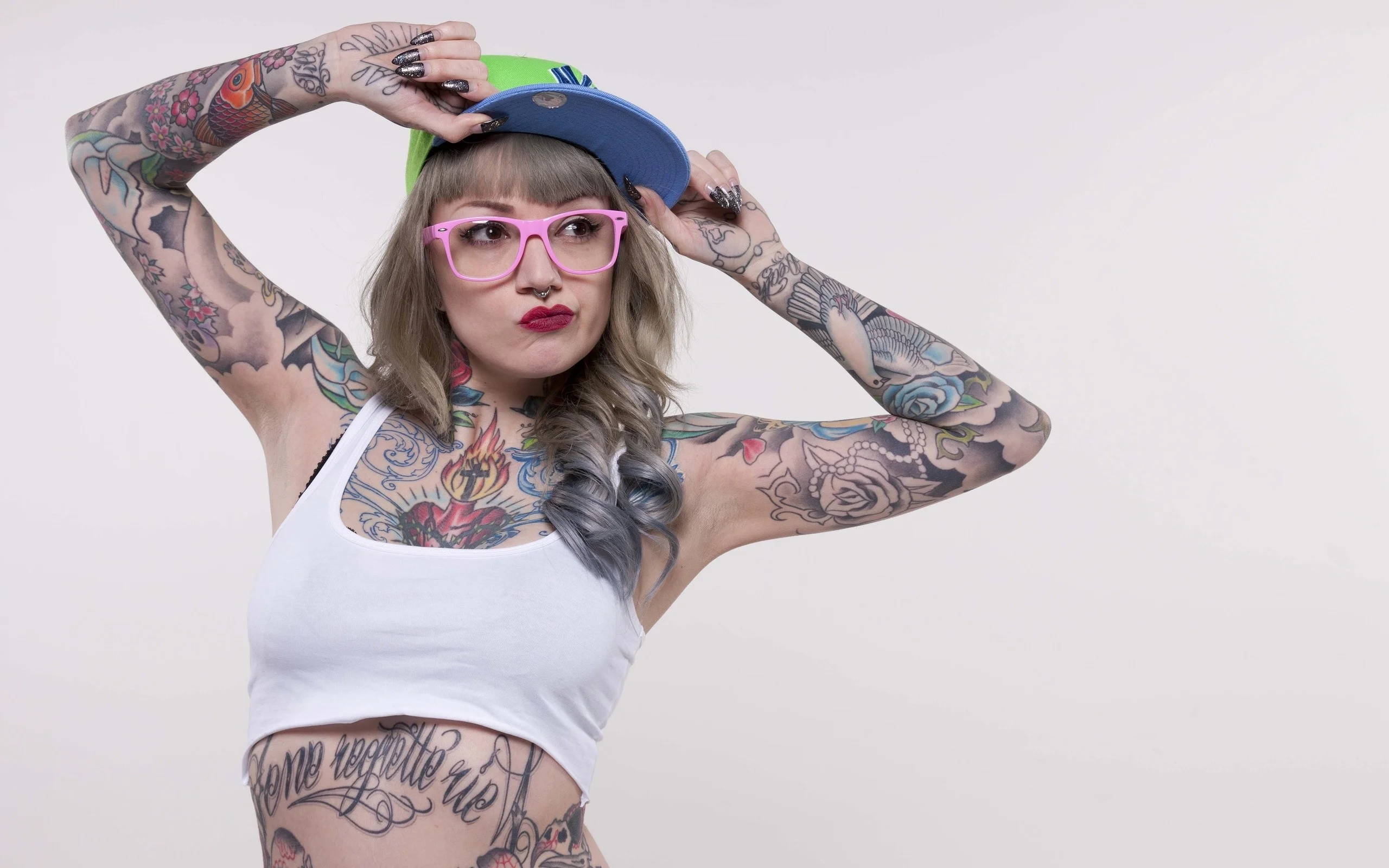Tattooed girl in hat and pink glasses