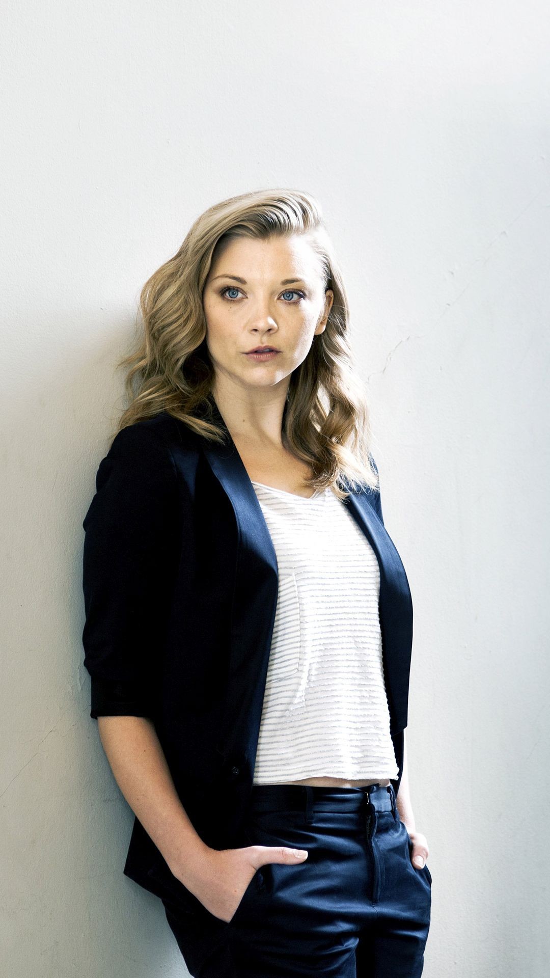 Natalie Dormer with hands in her pocket leaning on a wall Celebrity mobile wallpaper