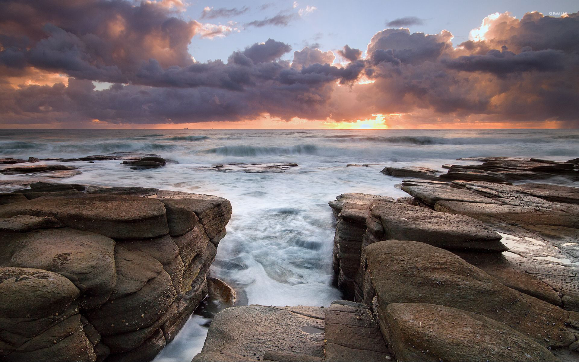 Waves rushing to the rocky shore wallpaper