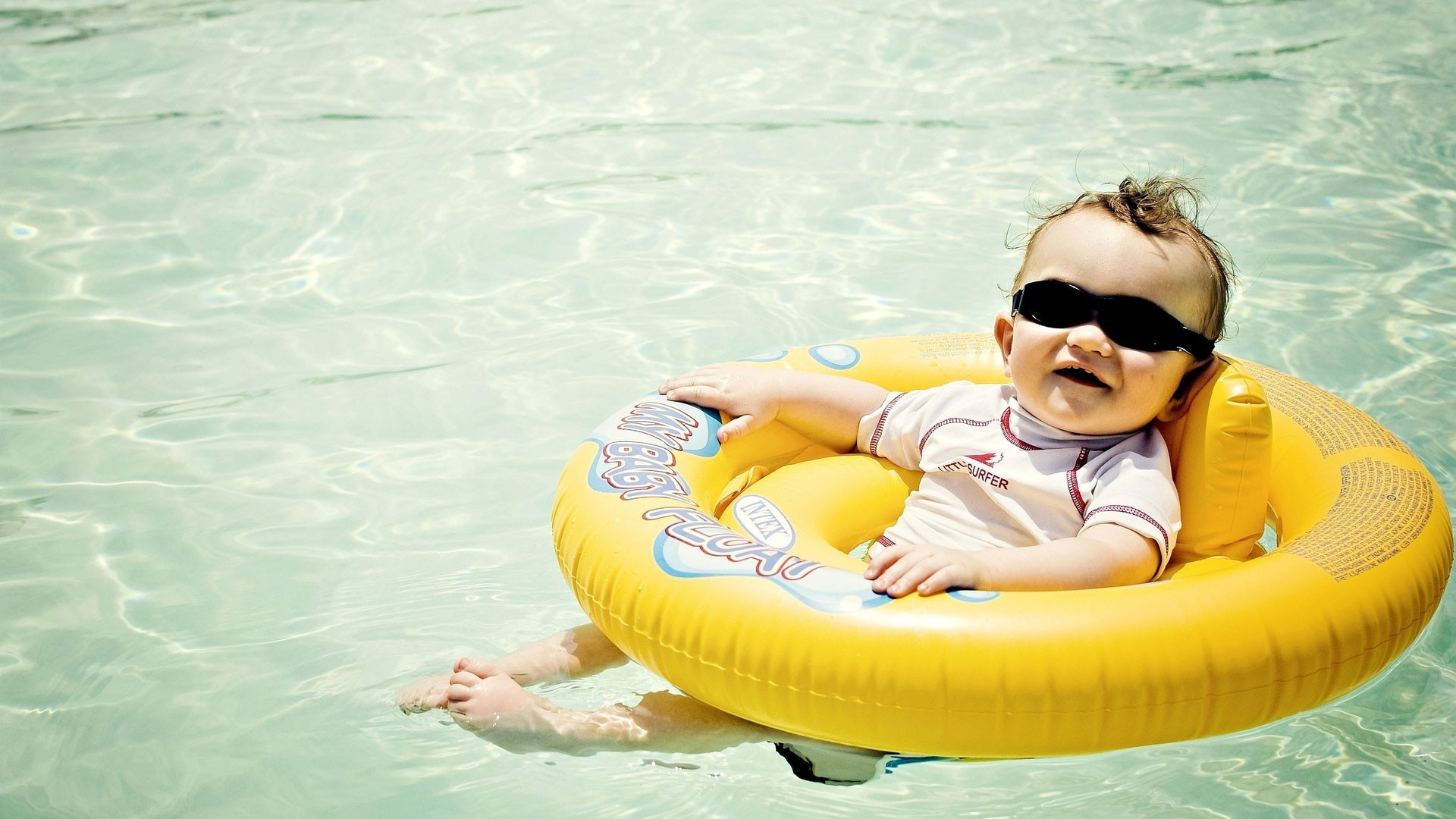 Funny babe boy in swimming pool wallpaper