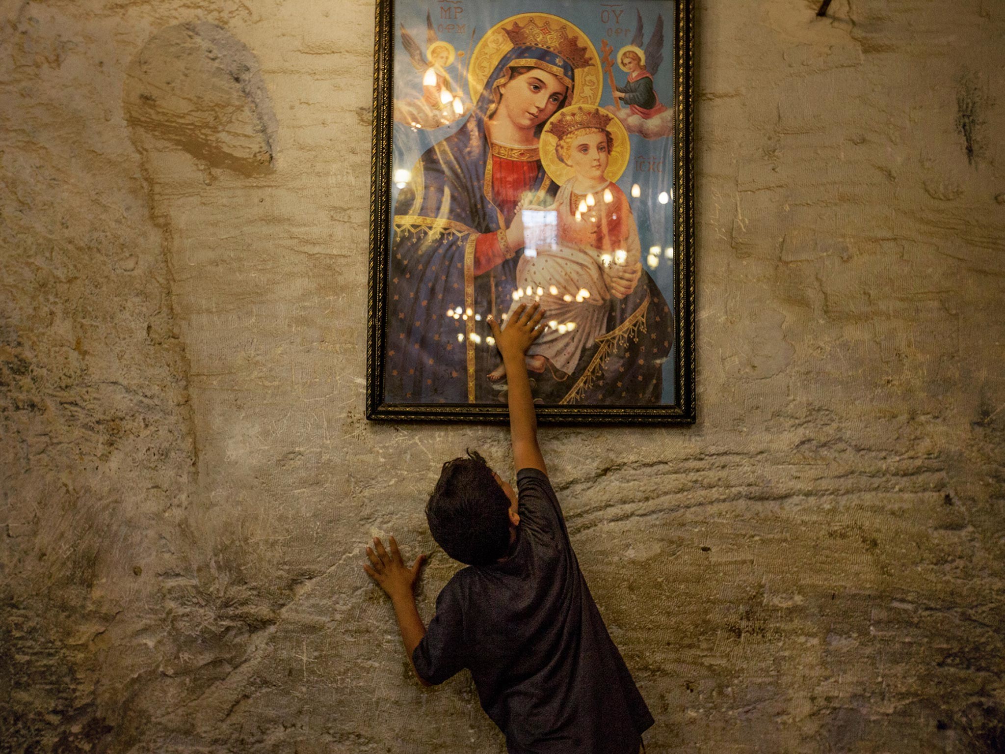 boy touches image of Mary and Jesus