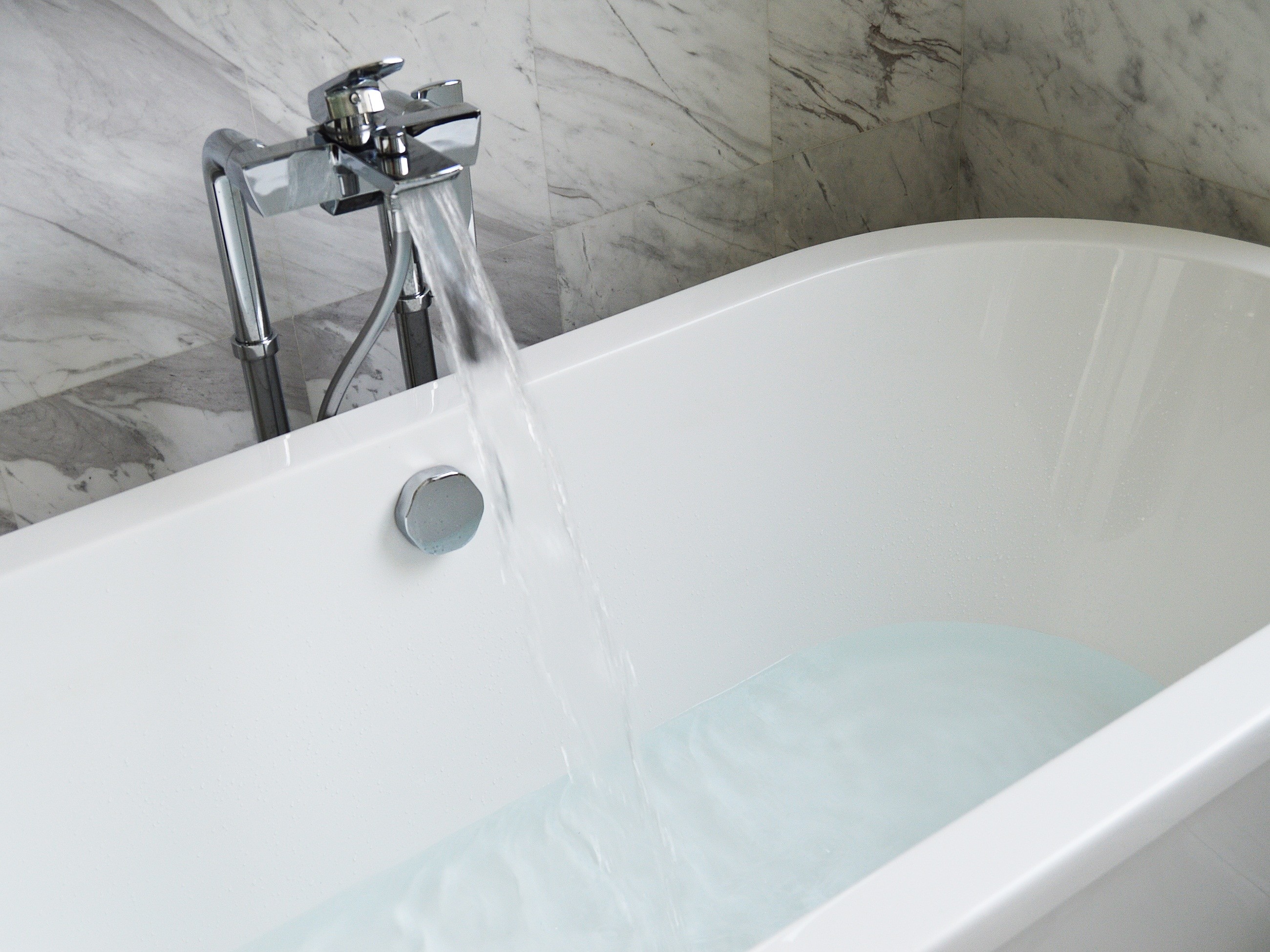 White porcelain oval bath tub and stainless steel faucet